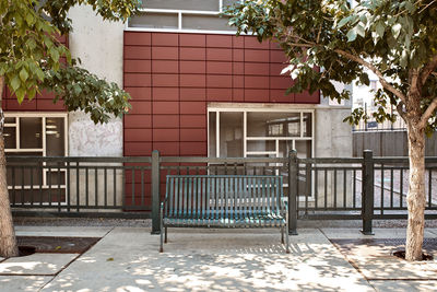 Empty chairs by footpath against building