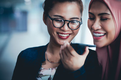 Portrait of a smiling young woman using smart phone