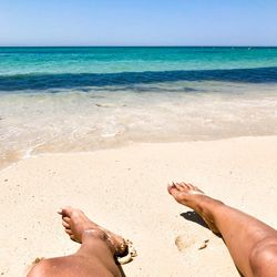 Low section of people relaxing on beach