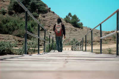 Portrait of man on footbridge against sky