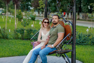 Portrait of smiling young couple sitting outdoors