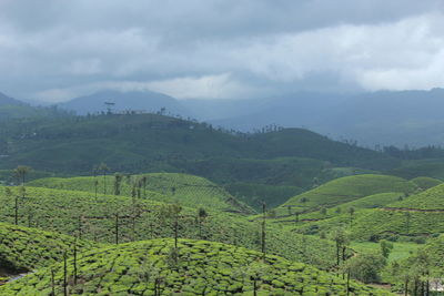 Scenic view of green landscape against cloudy sky