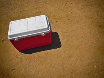 High angle view of cooler on sand