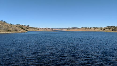 Scenic view of lake against clear blue sky