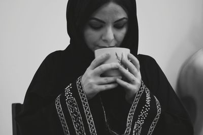 Portrait of young woman drinking coffee