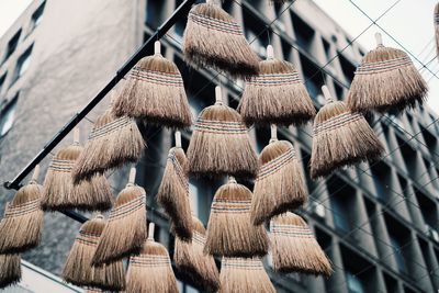 Low angle view of brooms hanging against building