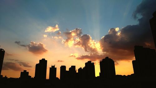 Silhouette buildings against sky during sunset