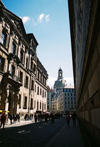 People in town square against sky in city