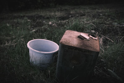 Close-up of old abandoned container on field