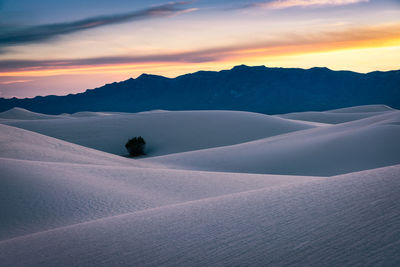 Scenic view of snowcapped mountains against sky during sunset
