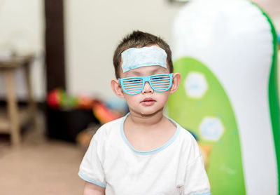 Portrait of boy wearing sunglasses at home