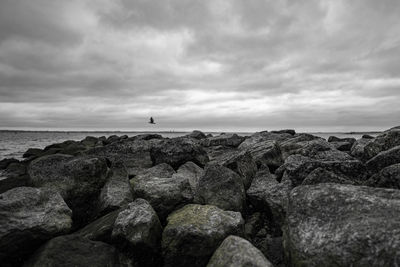 Rocks by sea against sky