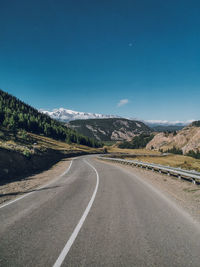 Road leading towards mountains against sky