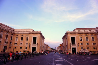 Road amidst buildings in city against sky