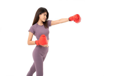 Full length portrait of woman standing against white background