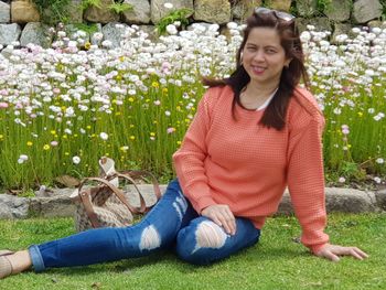 Portrait of a smiling young woman sitting on grass