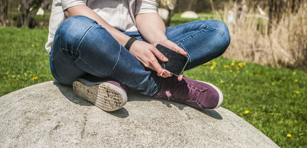 Low section of woman sitting on grass