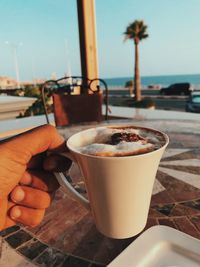 Close-up of hand holding coffee cup