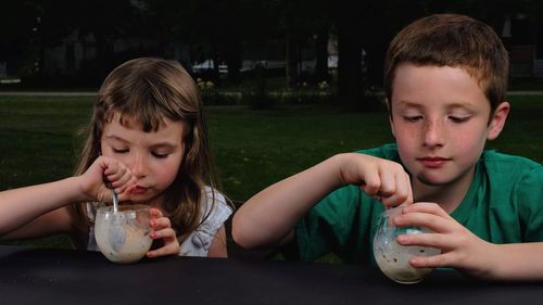 Portrait of boy drinking water from glass on table