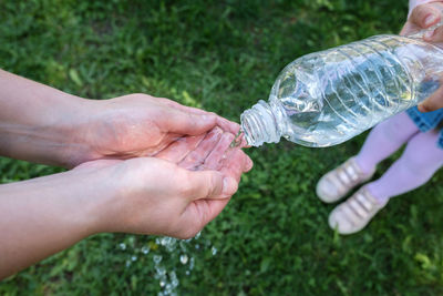 Water stream on woman hands. children's hands with a bottle of drinking water