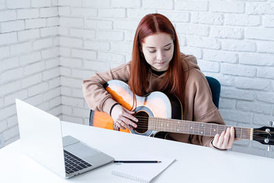 Portrait of young woman using laptop at home