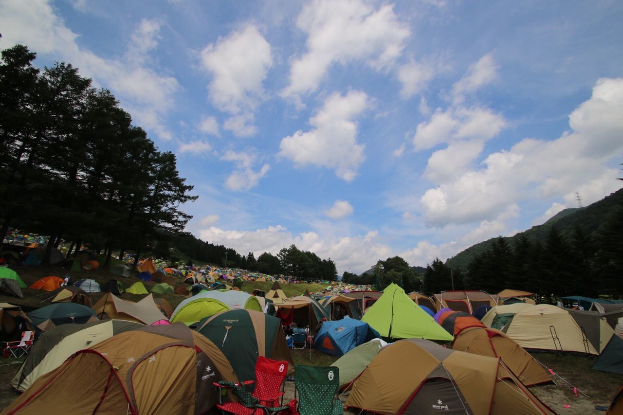 sky, cloud - sky, tree, abundance, lifestyles, crowd, leisure activity, outdoors, nature, landscape, cloud, day, mountain, tranquility, tent, beauty in nature, scenics, tranquil scene, growth, travel destinations, cloudy, tourism