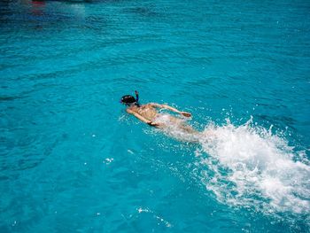 High angle view of woman swimming in sea on sunny day