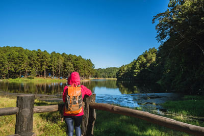 Full length of woman on lake against clear blue sky