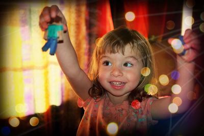 Cute smiling girl playing with toys at home