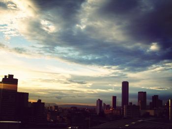 City skyline against cloudy sky