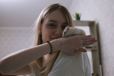 Happy girl with a small white syrian hamster. friendship between human and animal. 