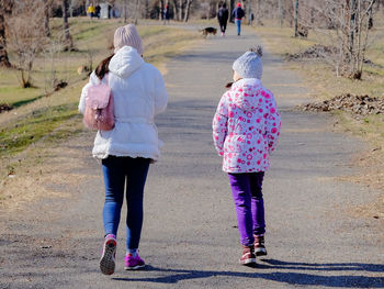 Rear view of women walking on footpath