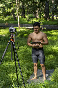 Hispanic latino man giving class, while being recorded by a camera, holding ipad or tablet 