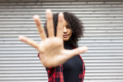 Woman showing stop gesture in front of shutter