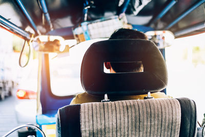 Rear view of man driving rickshaw in city