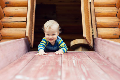 Smiling cute boy on slide in playground