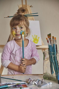 Charming child draws and stains everything with paints