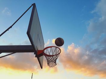 Low angle view of basketball hoop against sky during sunset