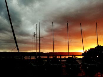Silhouette of boats moored at sunset