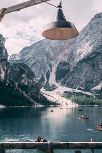 Bell hanging at lakeshore against mountains during winter