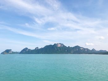 Scenic view of sea and mountains against blue sky