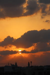 Silhouette buildings against sky during sunset