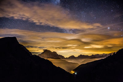 Scenic view of silhouette mountains against sky at night