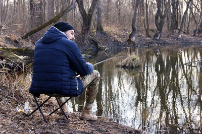 Rear view of man standing by lake