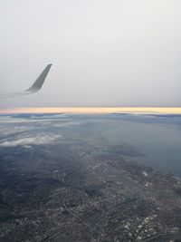 Airplane flying over sea against sky