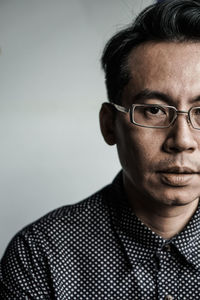 Close-up portrait of man against gray background