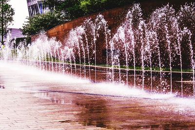 Water splashing in fountain against trees