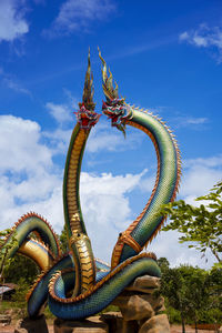  low angle twin stucco painted as a large serpent at pra kai keaw wang nakin,  udon thani, thailand.
