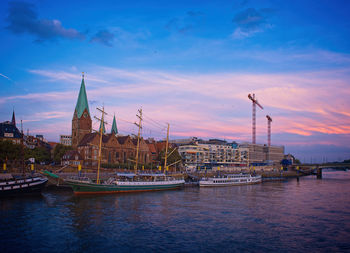 Sailboats in city at sunset