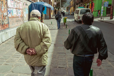 Rear view of men walking in city
